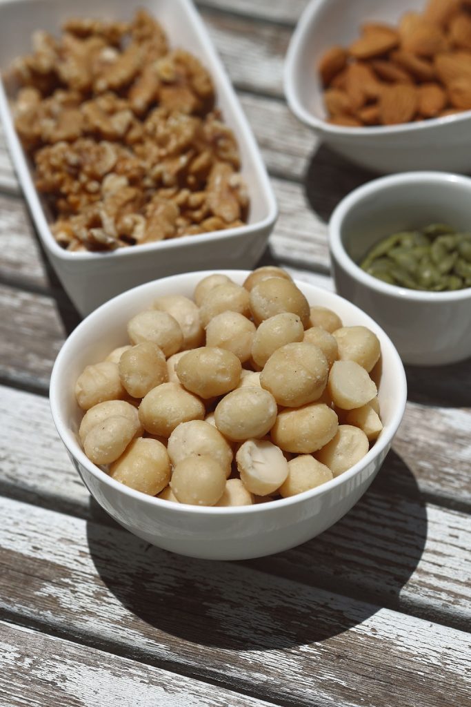 A table of bowls that have different types of nuts in them.