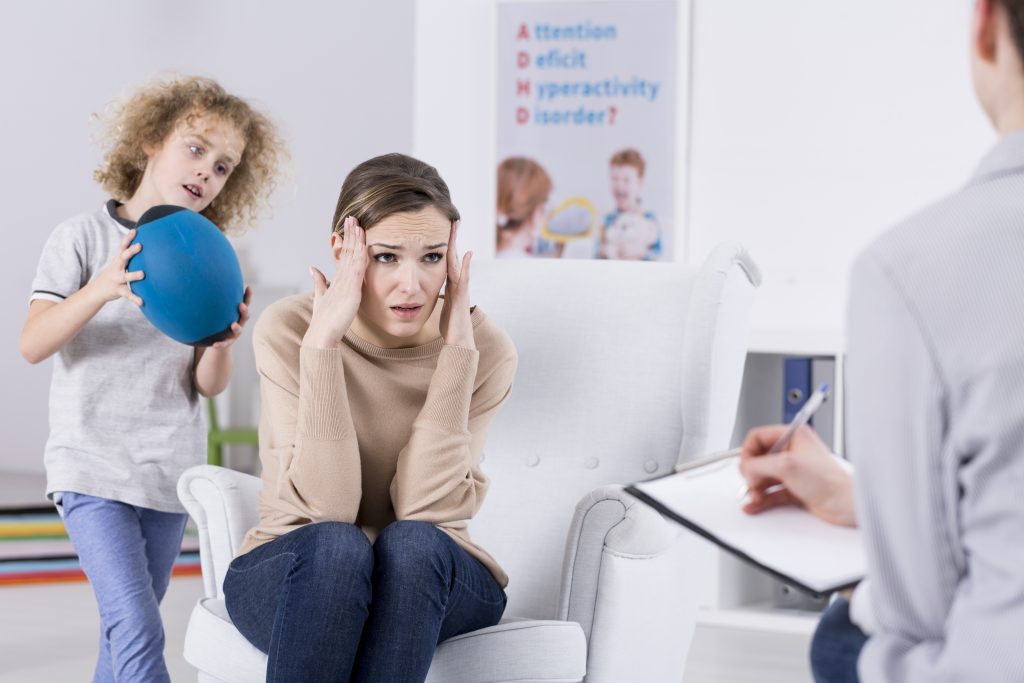 Helpless mother of ADHD child talking with psychologist