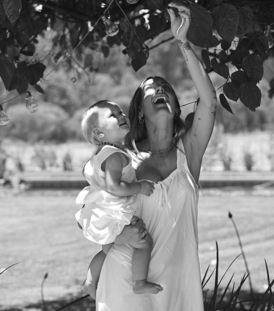 Elle-Lou Diddams standing by a tree with her baby.